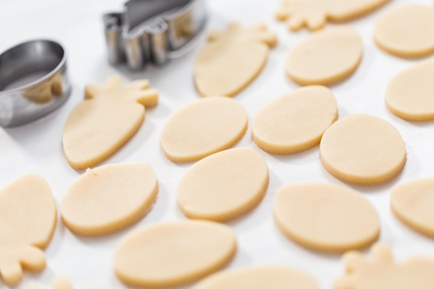 Galletas de azúcar de Pascua sin hornear sobre una mesa blanca.