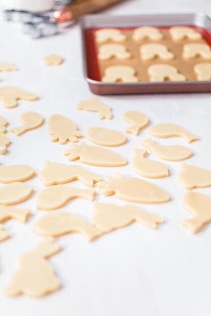 Galletas de azúcar de Pascua sin hornear sobre una mesa blanca.