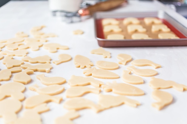 Galletas de azúcar de Pascua sin hornear sobre una mesa blanca.