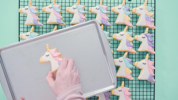 Foto galletas de azúcar de unicornio decoradas con glaseado real y brillo de alimentos.