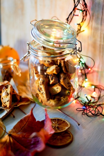 Galletas de banco y biscotti Guirnalda luminosa y hojas de otoño Cálida velada romántica