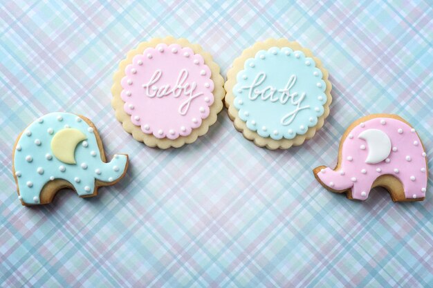 Galletas para bebés decoradas con glaseado sobre fondo de color