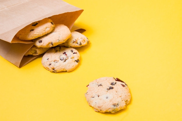 Galletas en una bolsa de papel sobre un fondo amarillo espacio de copia snack saludable