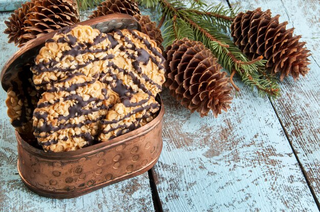 Galletas en caja de cobre y ramas de árboles de navidad