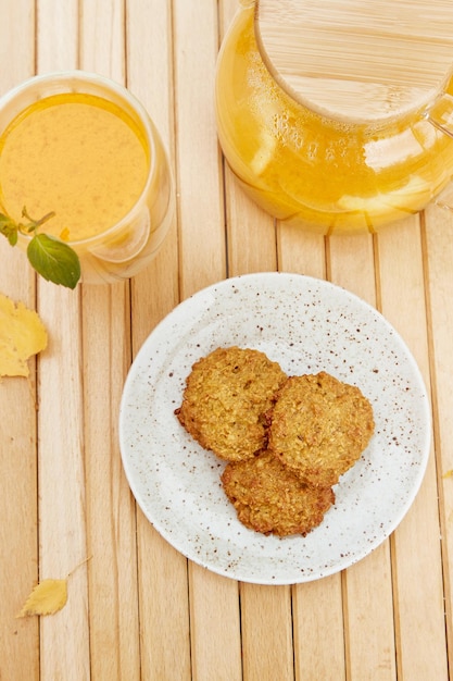 Galletas de calabaza veganas caseras estéticas con tetera y taza de té saludable de espino amarillo Desayuno saludable en la terraza Té natural de inmunidad aumentada a base de hierbas