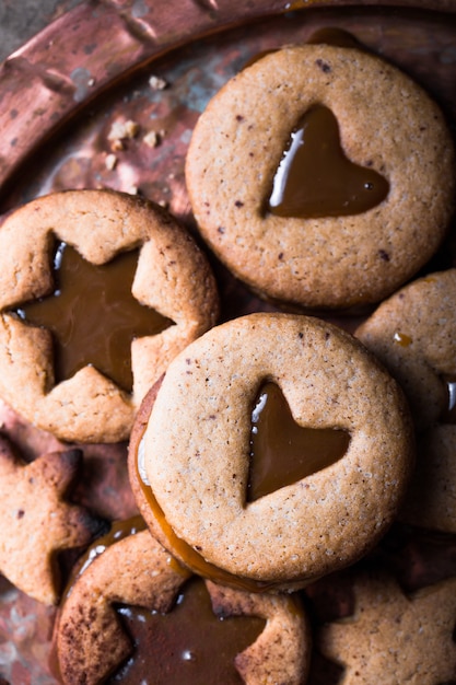 Galletas caseras del caramelo de la forma de la estrella del Año Nuevo de la Navidad sobre fondo de madera. Lay Flat, espacio.