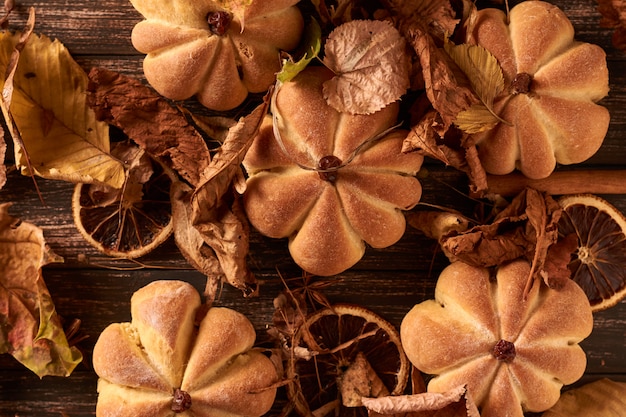 Galletas caseras en forma de calabaza en hojas de otoño