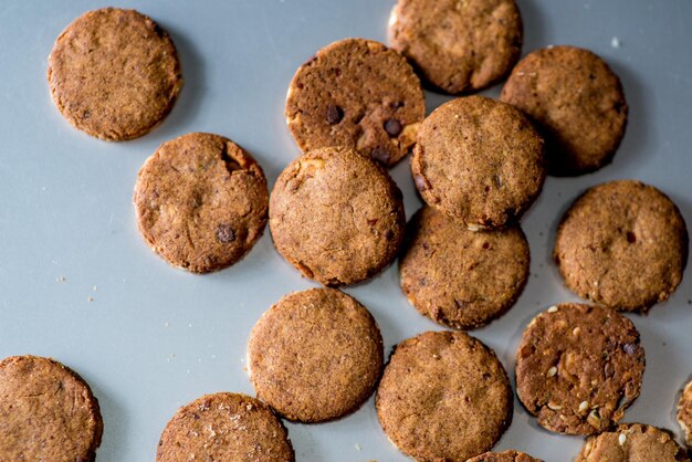 Galletas caseras redondas esparcidas sobre un fondo gris claro