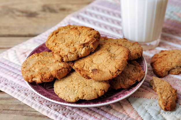 Galletas caseras y vaso de leche en la mesa de cerca