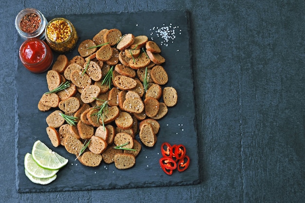 Galletas de centeno sobre una tabla de piedra con especias y salsa