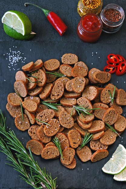 Galletas de centeno sobre una tabla de piedra con especias y salsa