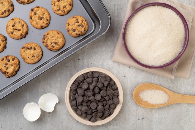 Galletas con chispas de chocolate en una bandeja para hornear con ingredientes.