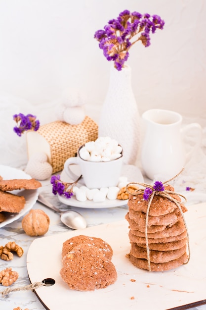 Galletas de chispas de chocolate caseras con nueces en el tablero de la cocina. Mesa puesta para el desayuno