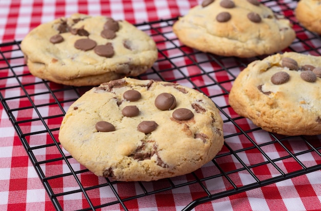 Galletas de chispas de chocolate en una cuadrícula sobre una tela a cuadros