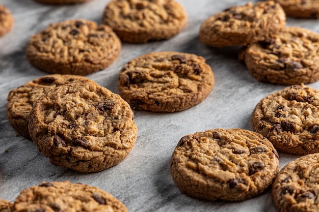 Galletas de chispas de chocolate recién horneadas en una encimera de mármol.