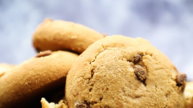 Galletas con chispas de chocolate suaves y recién horneadas en una encimera de cocina de mármol gris. Pastelería dulce tradicional americana, delicioso postre casero. Fondo culinario. De cerca