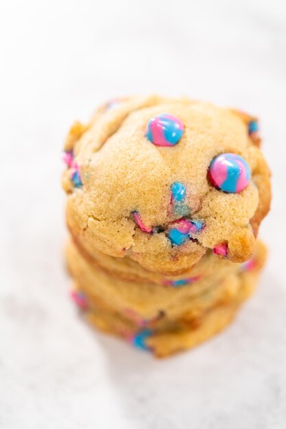 Galletas de chispas de chocolate de unicornio recién horneadas con chispas de chocolate de arco iris en el mostrador.