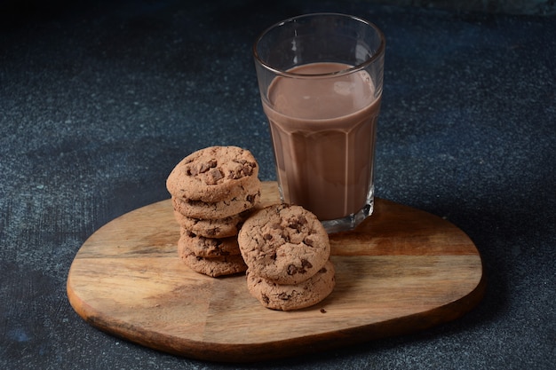 Galletas de chispas de chocolate con vaso de sabrosa leche con chocolate