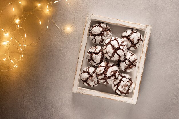 Galletas de chocolate arrugadas en caja de madera con luces navideñas Dulces caseros festivos