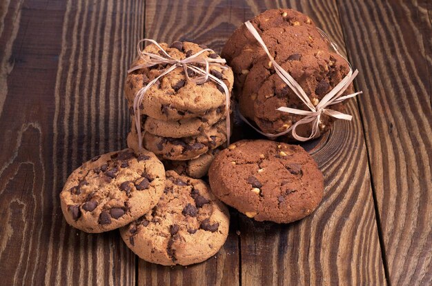 Galletas de chocolate atadas con una cinta en el primer plano de la mesa de madera oscura.