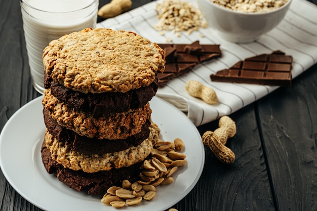 Galletas de chocolate y avena en mesa de madera oscura.