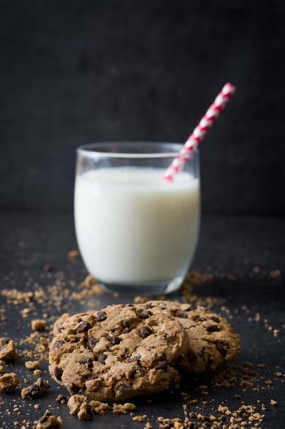 Galletas de chocolate caseras y leche en pizarra negra