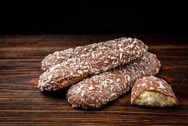 Galletas de chocolate con coco en la mesa de madera oscura.