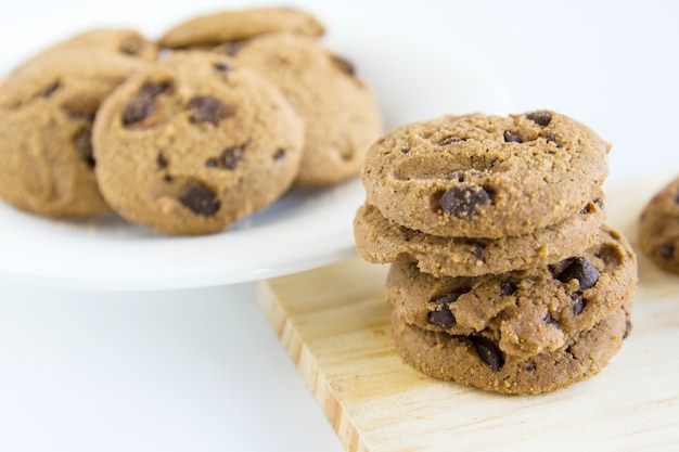 Galletas de chocolate en cortar madera y plato blanco