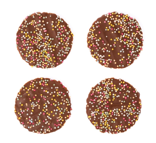 las galletas de chocolate espolvorean aisladas sobre fondo blanco.
