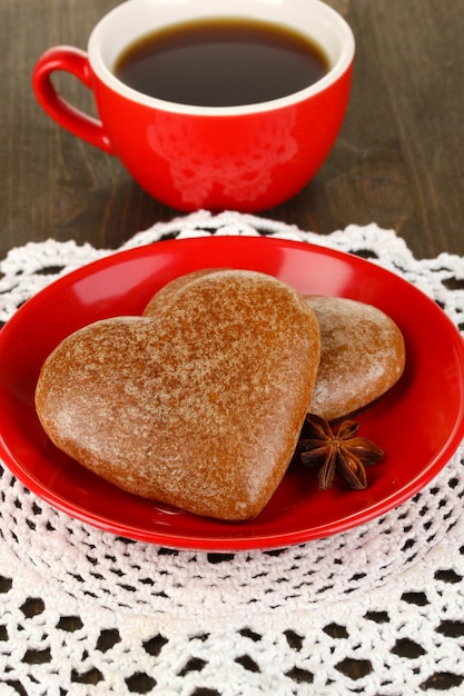 Galletas de chocolate en forma de corazón con taza de café en primer plano de la mesa de madera