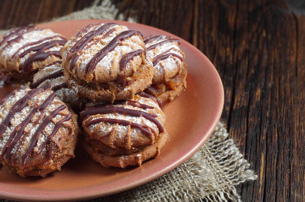 Galletas con chocolate y mermelada sobre mesa de madera rústica