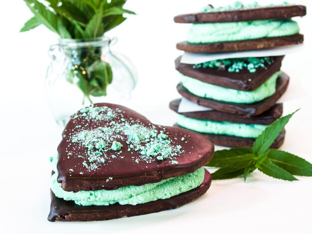 Galletas de chocolate con relleno de menta sobre fondo blanco.