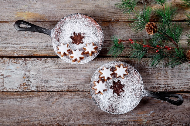 Galletas de chocolate sartén con galletas de estrella, ramas de abeto en mesa de madera