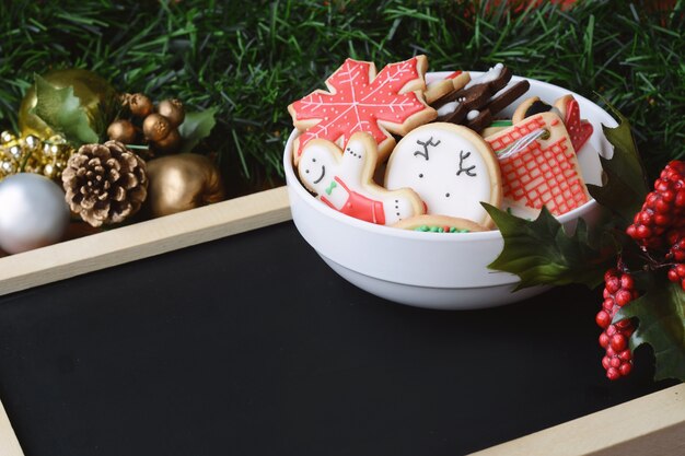 Galletas coloridas de la Navidad con la pizarra vacía y los ornamentos decorativos