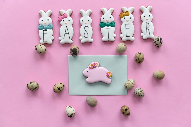 Galletas de conejito de chocolate con huevos de codorniz en un fondo rosa