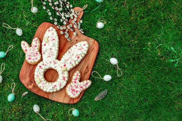 Galletas de conejito de pascua en un tablero sobre una hierba verde