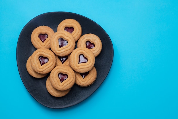 Galletas con corazones en plato oscuro