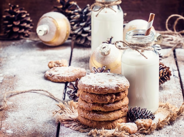 Galletas y crema de año nuevo en las decoraciones festivas fondo de madera vintage enfoque selectivo