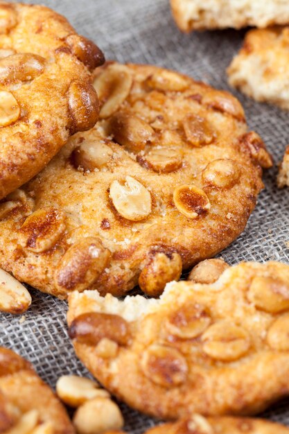 Galletas crujientes con maní tostado, sobre la superficie de una galleta fresca redonda de caramelo con maní, deliciosas galletas redondas de diferentes ingredientes