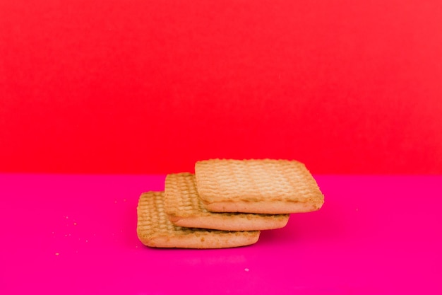 Galletas cuadradas sobre un fondo rosa en la mesa