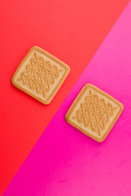 Galletas cuadradas sobre un fondo rosa en la mesa