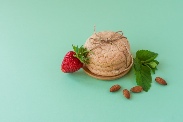 Galletas de Cuaresma útiles de harina de almendras con nueces y fresas sobre fondo verde. enfoque selectivo.