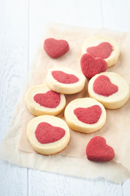 Galletas del día de San Valentín Galletas de mantequilla dentro de un dulce corazón rojo sobre papel pergamino sobre fondo blanco Día de la madre Día de la mujer Dulces vacaciones hornear Vista superior