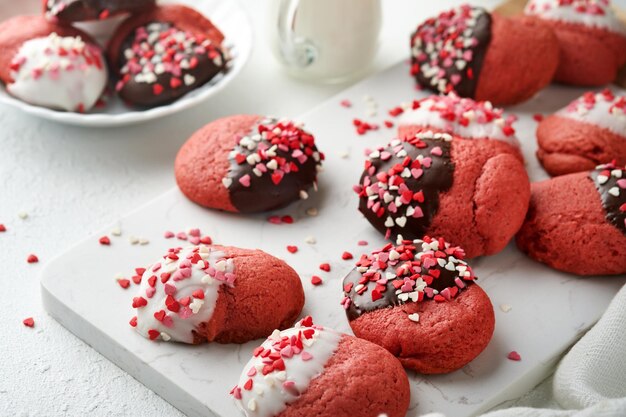 Galletas del día de San Valentín Galletas de mantequilla con glaseado de chocolate blanco y negro y chispas de corazón en un plato sobre fondo blanco Día de la madre Día de la mujer Dulces vacaciones para hornear Vista superior