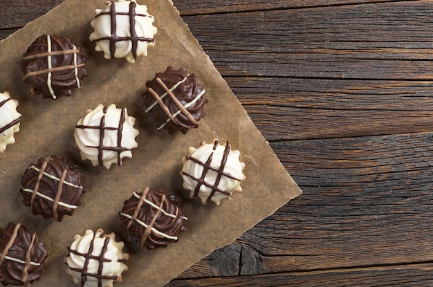 Galletas dulces con chocolate blanco y marrón en la vista superior de fondo de madera oscura