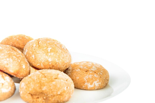 Galletas dulces en plato blanco aislado sobre fondo blanco.