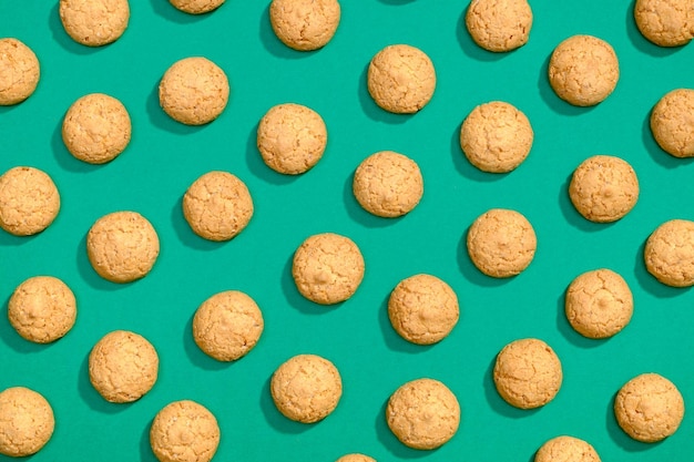 Foto las galletas dulces tienen un patrón plano sobre un fondo verde oscuro