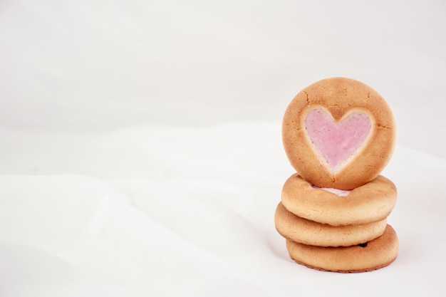 Galletas de esponja con un corazón y una taza blanca Fondo para los amantes en el Día de San Valentín