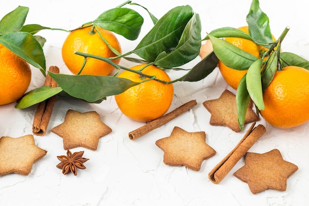 Galletas de estrella de Navidad con especias y mandarina sobre fondo blanco con copyspace. Vista superior