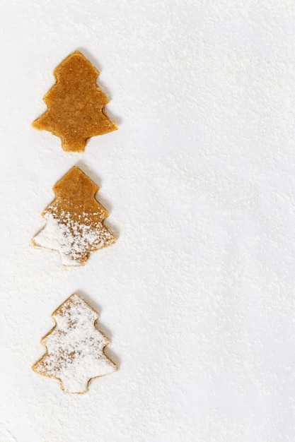 Galletas en forma de árbol de navidad en papel para hornear.